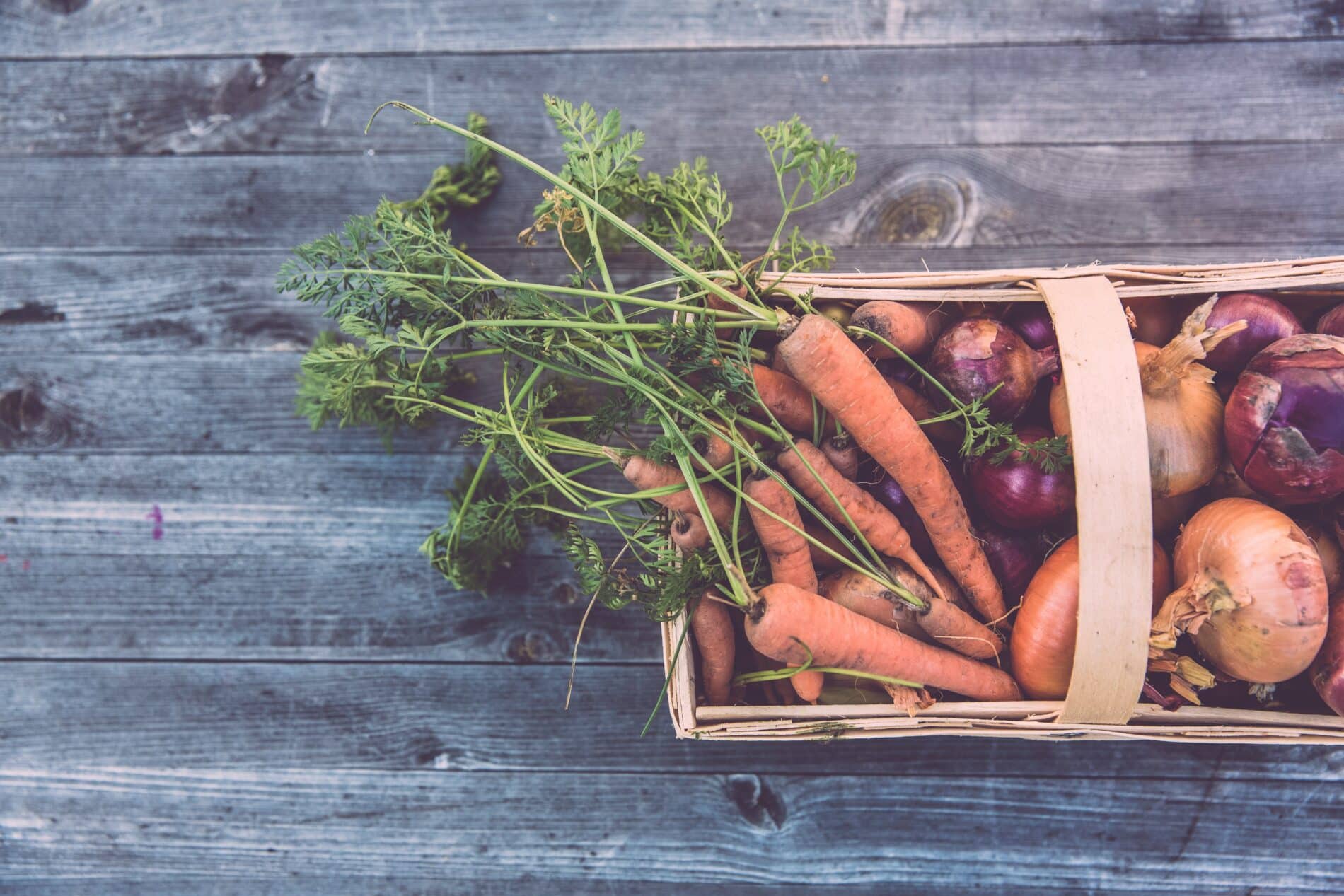 Panier de légumes locaux : carottes, oignons